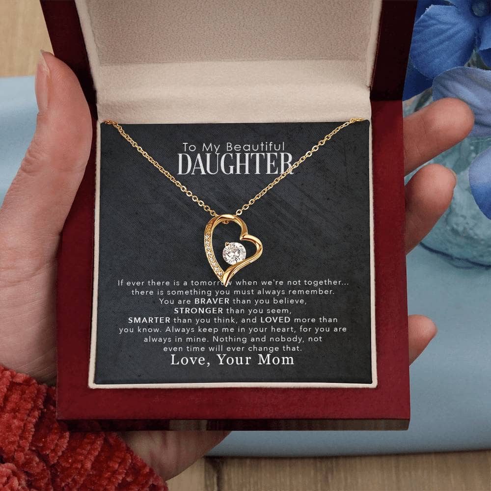 A hand holding a Personalized Daughter Necklace in a box, symbolizing the boundless love and strength of parent-daughter relationships.