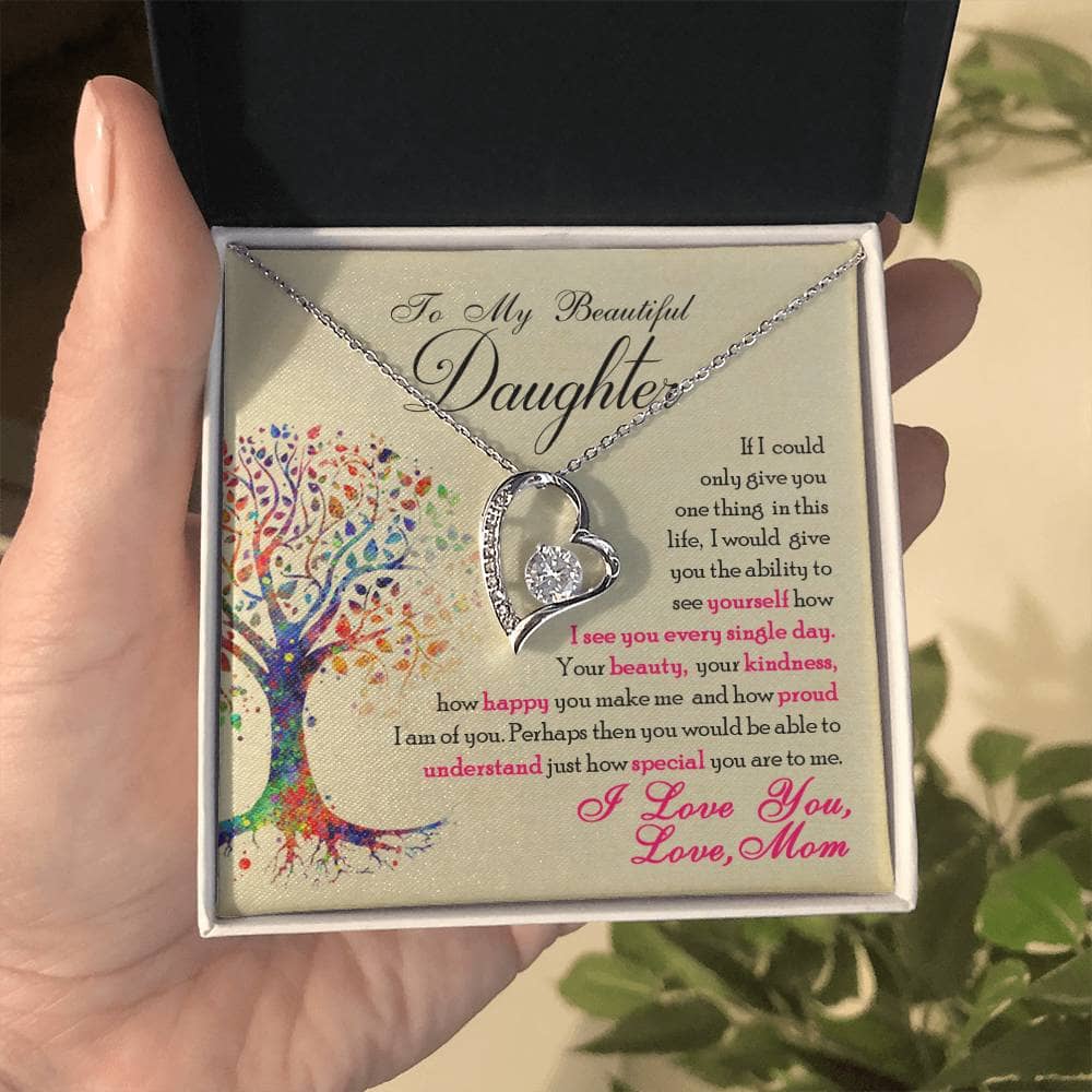 A hand holding a personalized 'To My Daughter' necklace in a box, symbolizing the unbreakable bond between parents and their daughters.