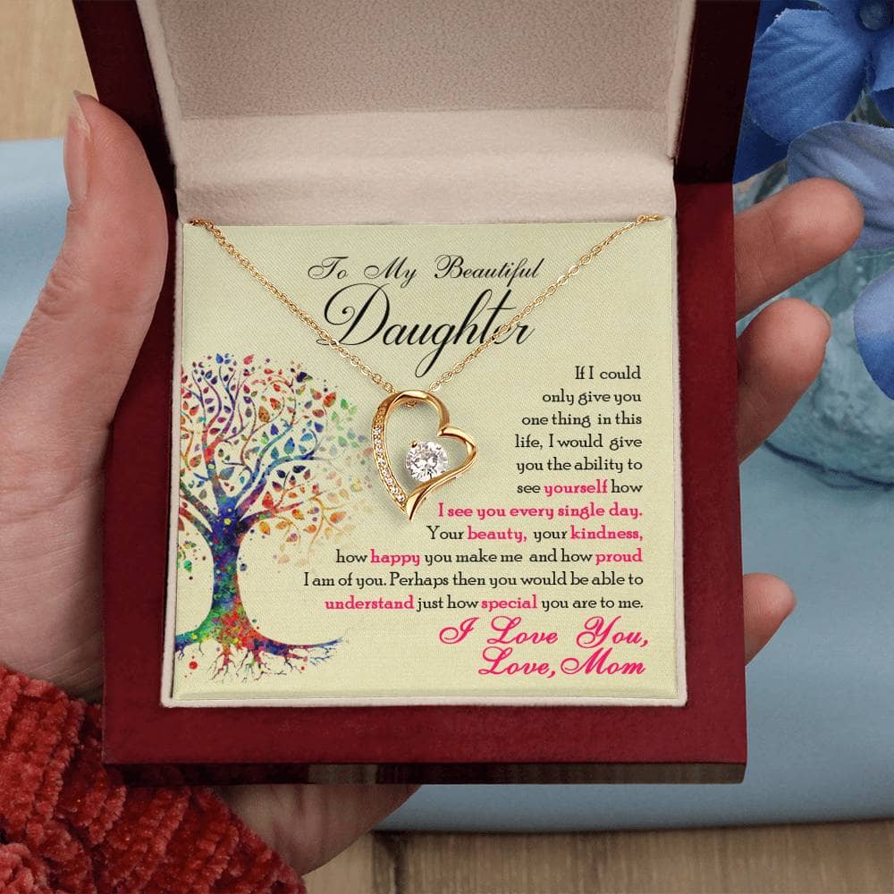 A hand holding a personalized 'To My Daughter' necklace in a box.