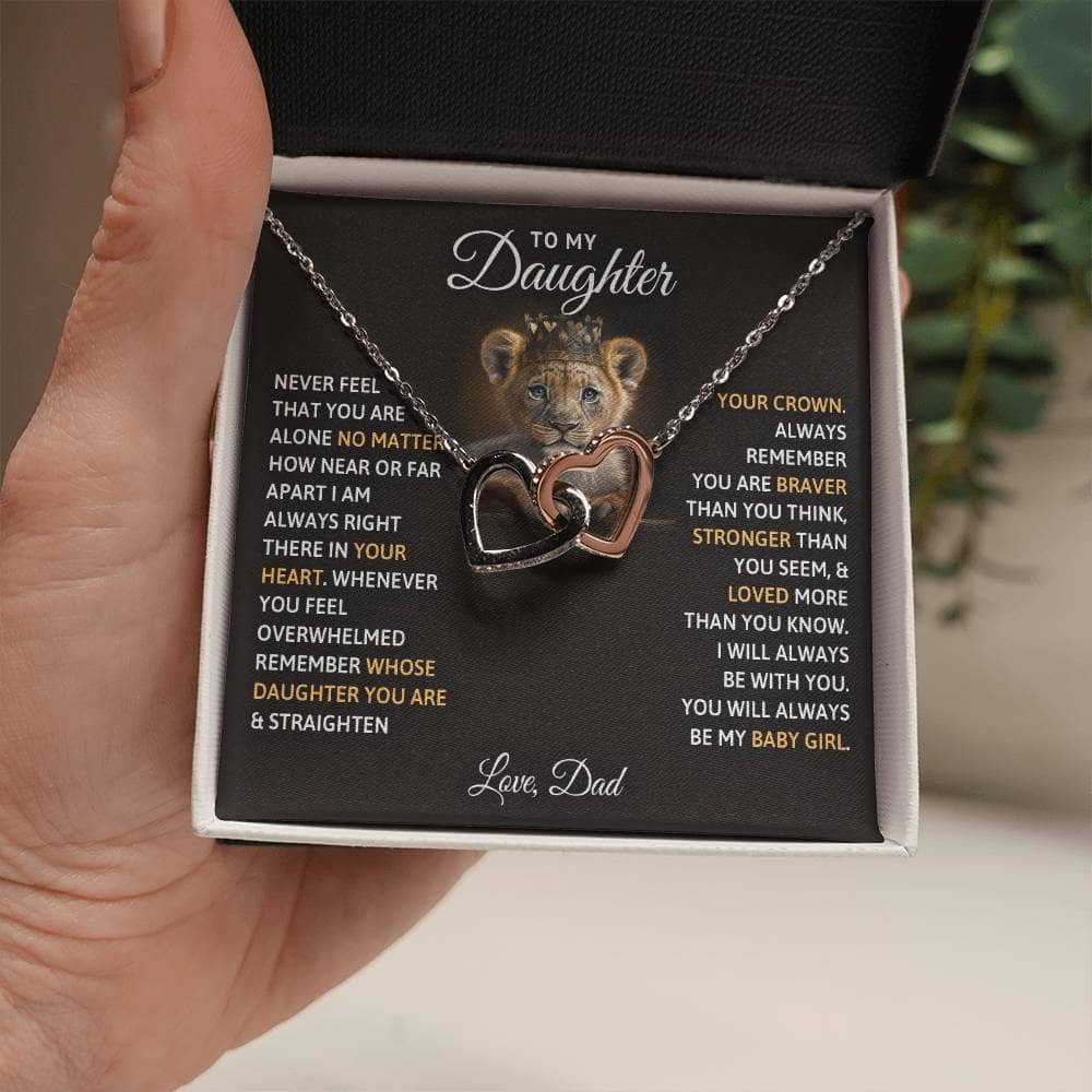 Alt text: "A hand holding a personalized daughter necklace with twin hearts pendant"