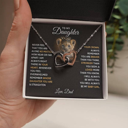 Alt text: "A hand holding a personalized daughter necklace with twin hearts pendant"