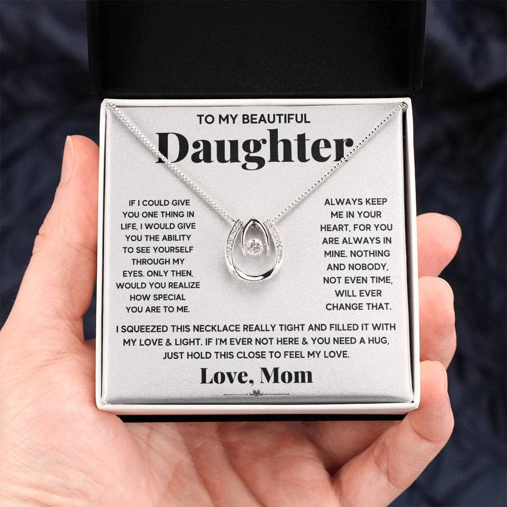 Alt text: "A hand holding a Personalized Daughter Necklace with Cushion-Cut Cubic Zirconia in a box, symbolizing the deep bond between parent and daughter."