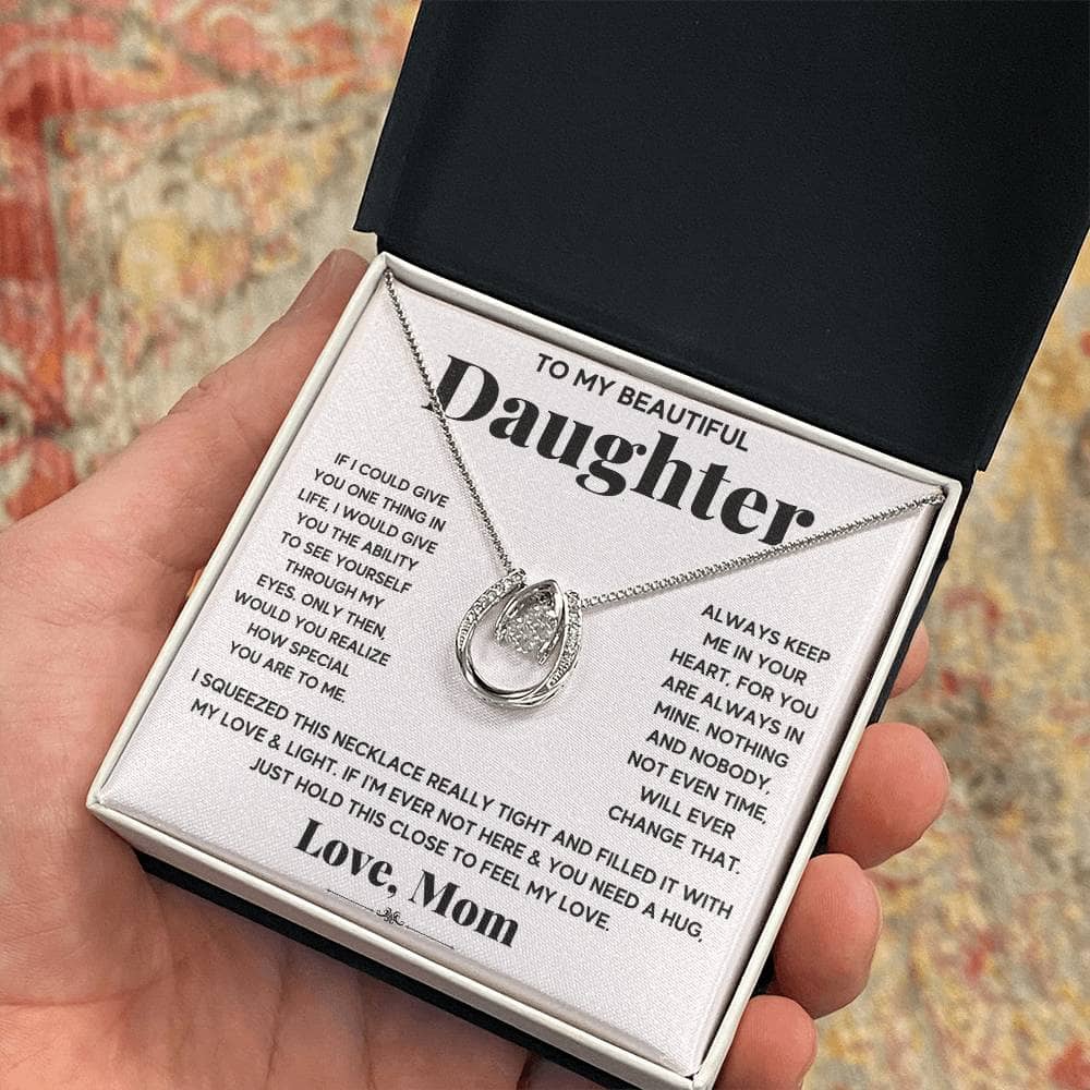 A hand holding a Personalized Daughter Necklace with Cushion-Cut Cubic Zirconia in a box.