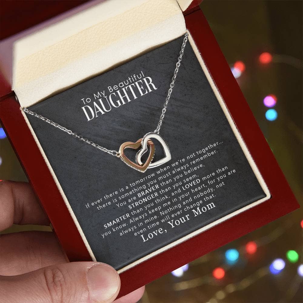 A hand holding a Personalized Daughter Necklace with Cushion-Cut Zirconia Pendant in a box.