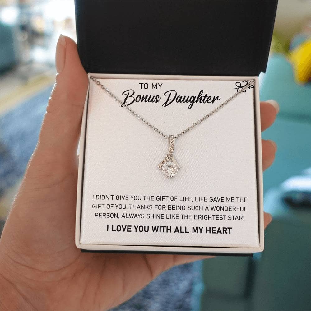A hand holding a Personalized Daughter Necklace with Heart-shaped Pendant in a box.
