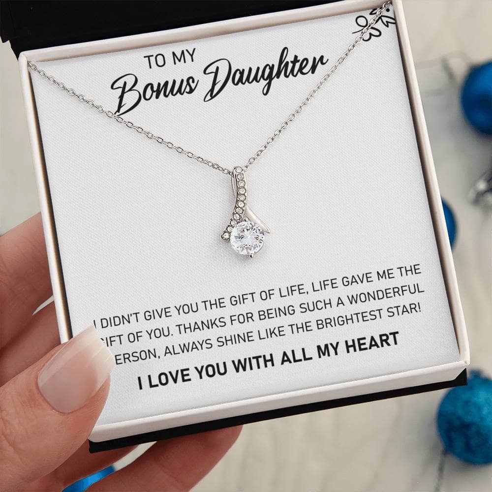 A hand holding a Personalized Daughter Necklace with a heart-shaped pendant, symbolizing the unbreakable bond between parents and daughters.