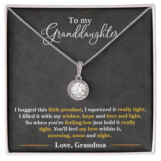 A close-up of the Personalized Granddaughter Heart Necklace, featuring a sparkling cushion-cut cubic zirconia pendant surrounded by accent CZ crystals. The necklace comes with an adjustable box chain and is packaged in a soft touch box for easy gifting.