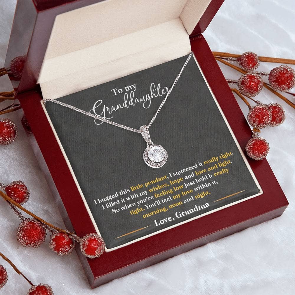 A personalized Granddaughter Heart Necklace, featuring a stunning cushion-cut cubic zirconia crystal surrounded by accent CZ crystals. Adjustable box chain length of 16"-18". Packaged in a soft touch box.
