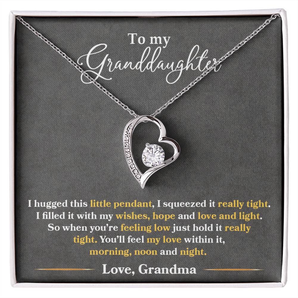 A close-up image of the Personalized Granddaughter Necklace - Forever Love Token. The necklace features a heart-shaped pendant with a dazzling 6.5mm round cut cubic zirconia stone. Crafted with love, this necklace is available in 14k white gold or 18k yellow gold finish.