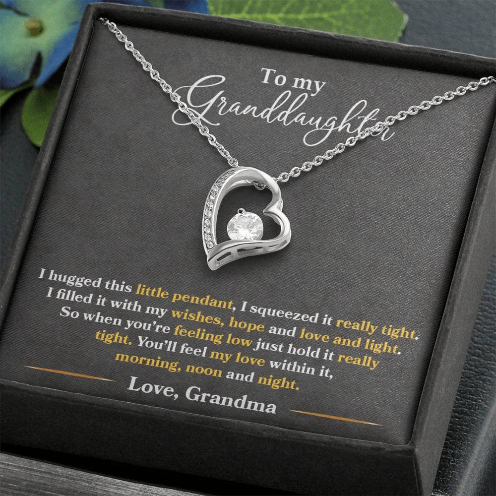 Alt text: "Personalized Granddaughter Necklace - Forever Love Token: A necklace in a box, featuring a heart-shaped pendant with a 6.5mm CZ crystal, available in white gold or yellow gold finish."