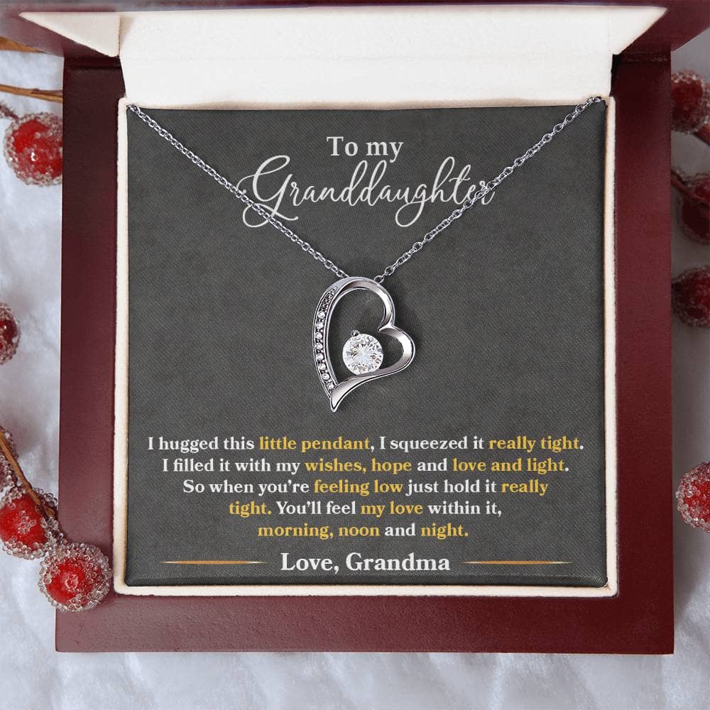 A close-up of a heart-shaped pendant necklace in a box from the Personalized Granddaughter Necklace - Forever Love Token collection.