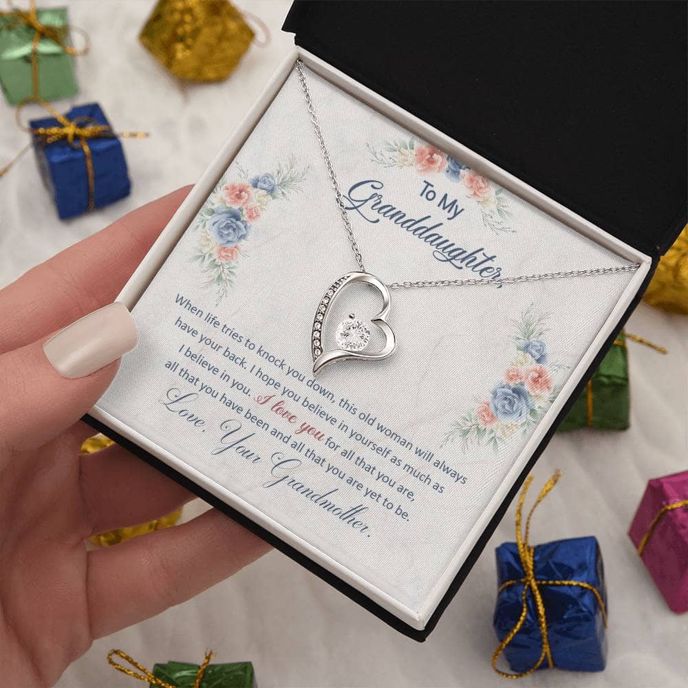 Alt text: "A hand holding a Personalized Granddaughter Necklace of Love in a luxury box with LED lighting."