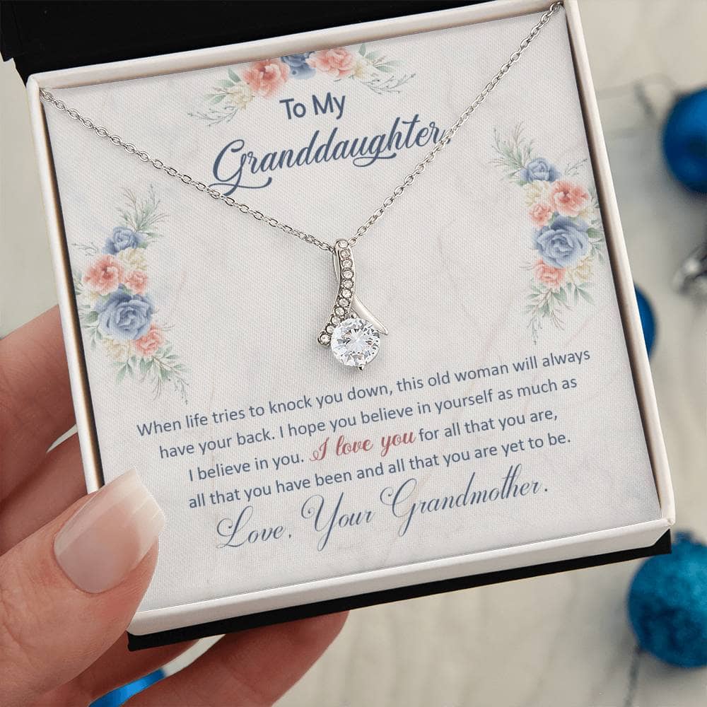 Alt text: "A hand holding a Personalized Keepsake Necklace for Granddaughter in an exquisite gift box with LED lighting."