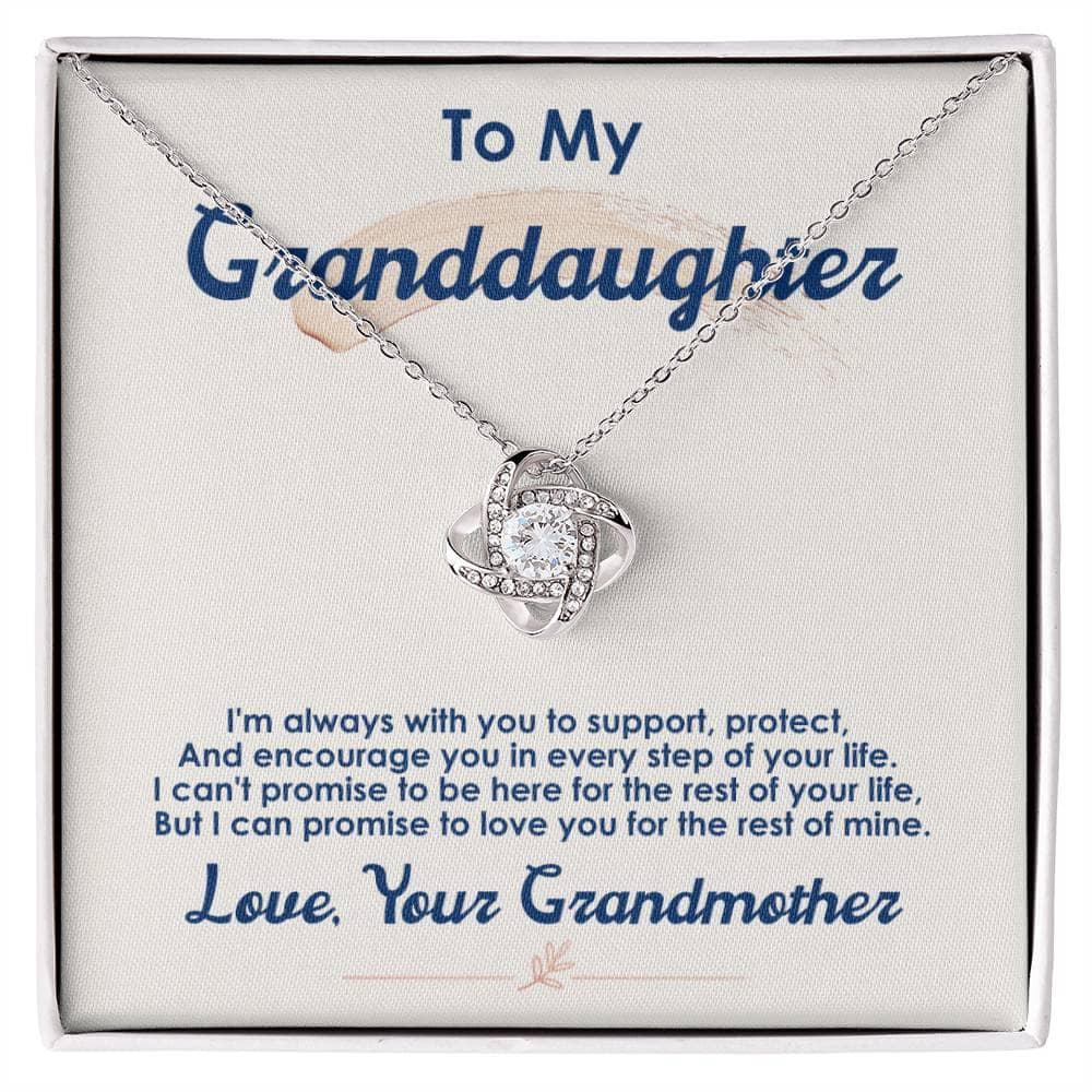 Alt text: "Personalized Love Knot Necklace for Granddaughter - A stunning necklace with a heart-shaped pendant adorned with cubic zirconia crystals, symbolizing the unbreakable bond between grandparents and child. Comes in a sophisticated mahogany-style box with LED lighting."