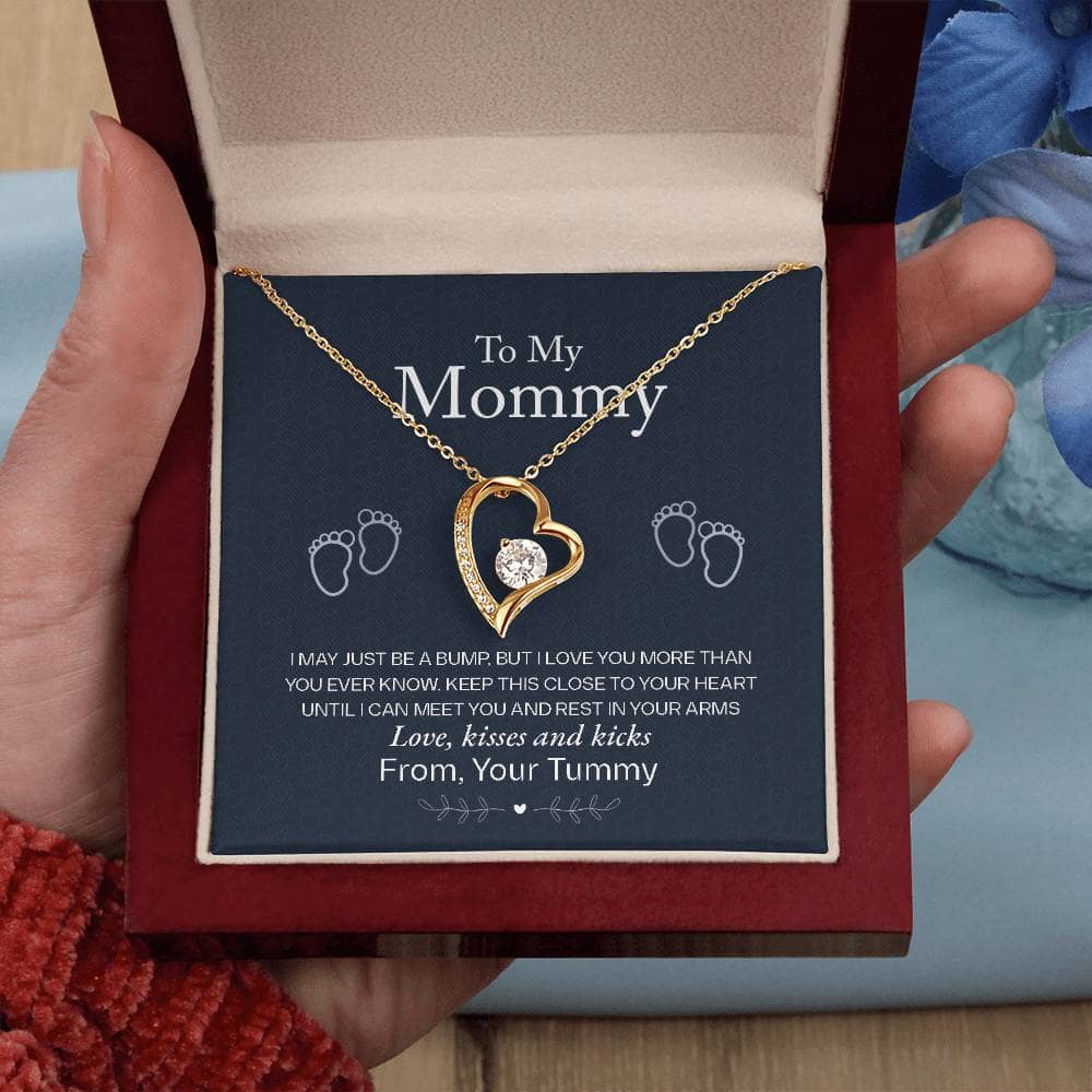 Alt text: A hand holding a gold heart necklace in a box from the Personalized Mother Necklace - A Gift of Love from Children collection.