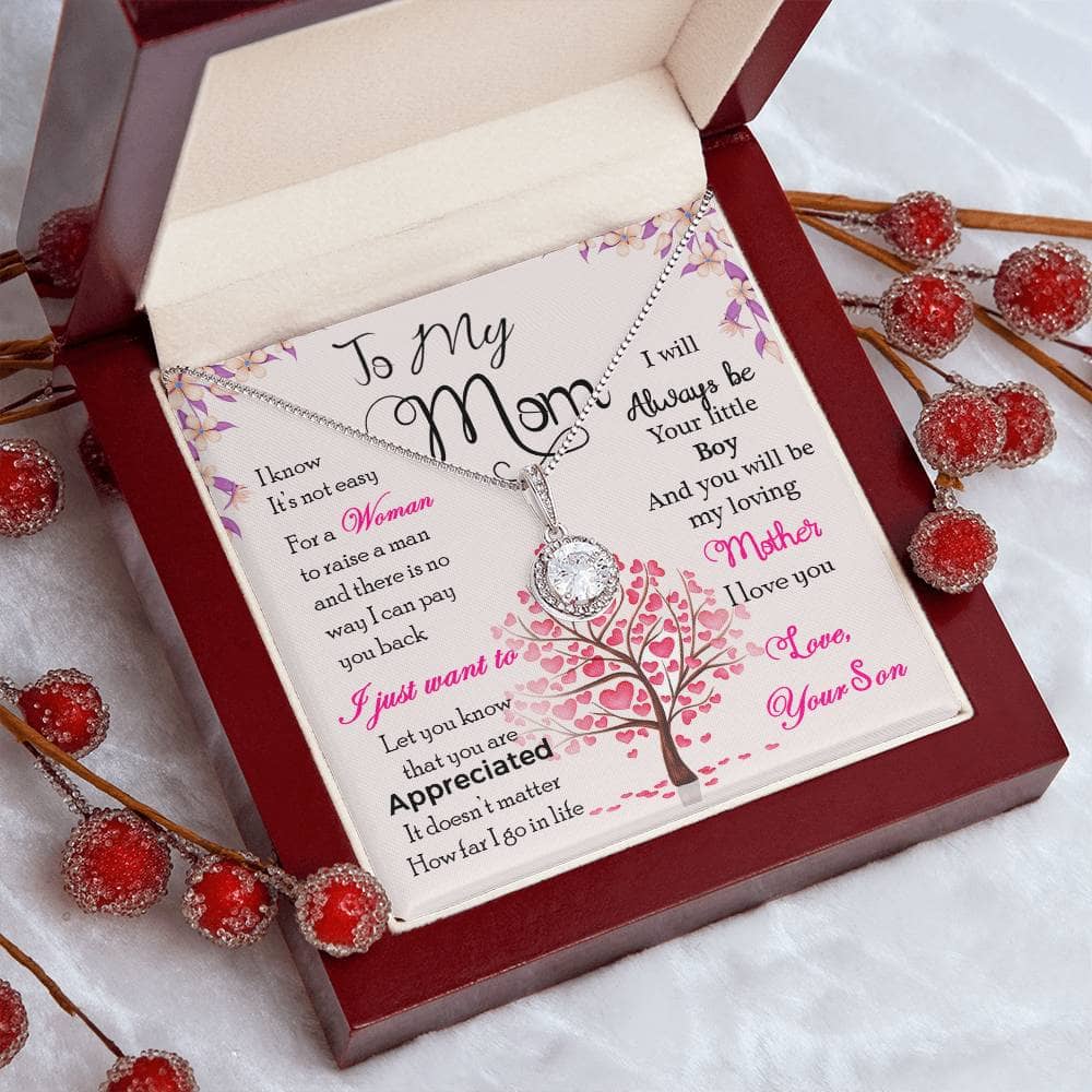 A necklace in a box with a note and red berries, part of the Personalized Mother Necklace Collection - A Gift Of Love From Son Or Daughter.
