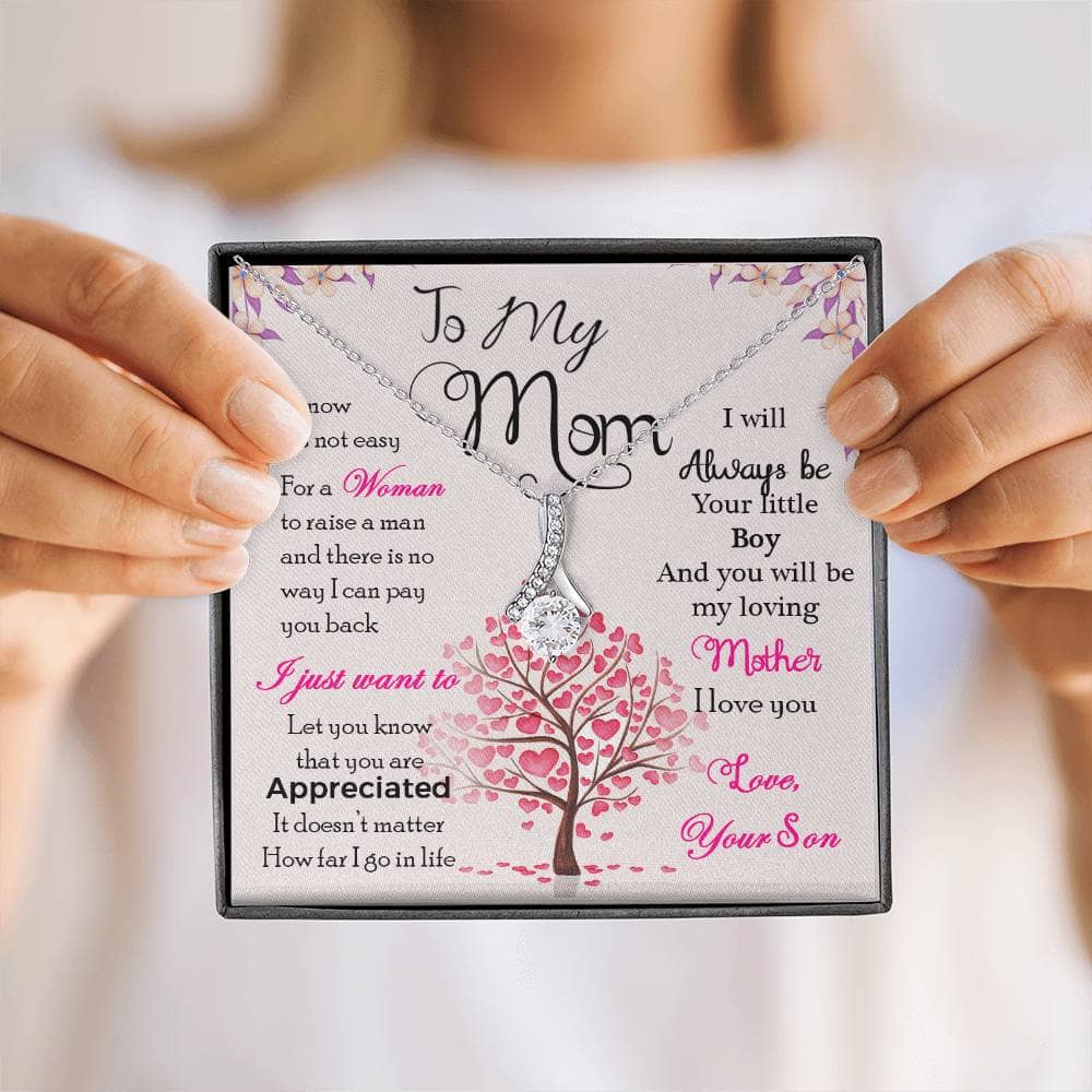 Alt text: "A person holding a Personalized Mother Necklace - A Heartfelt Gift From Sons/Daughters, featuring a heart-shaped pendant and premium cushion-cut cubic zirconia."