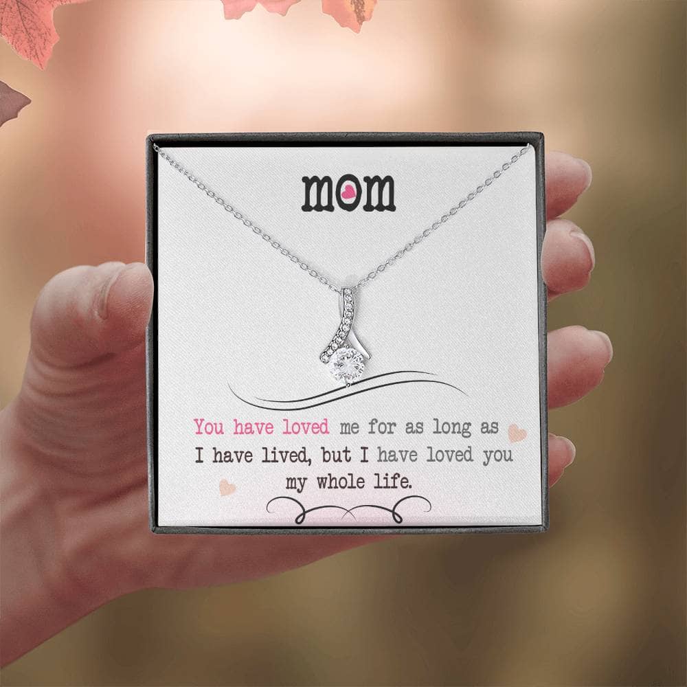 A hand holding a necklace with an elegant heart pendant, a symbol of the profound love between a mother and her child.