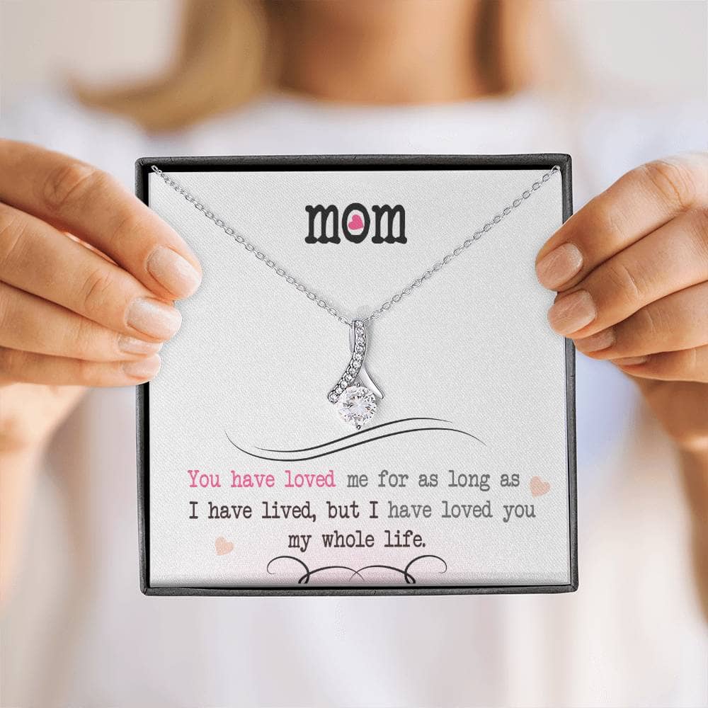 A person holding a Personalized Mother Necklace with an elegant heart pendant, symbolizing the bond between a mother and child.