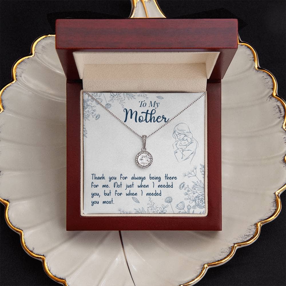 Alt text: "Personalized Mother Necklace - A necklace in a box on a plate, featuring a heart-shaped pendant with a Luxurious Cushion-Cut Cubic Zirconia stone, symbolizing maternal love and strength."