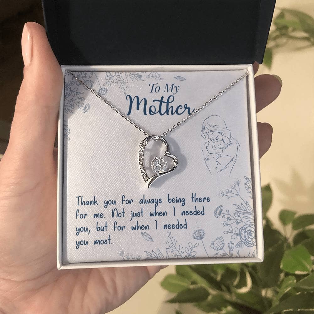 A hand holding a necklace in a box from the Personalized Mother Necklace Collection - From Child's Heart To Mom's.