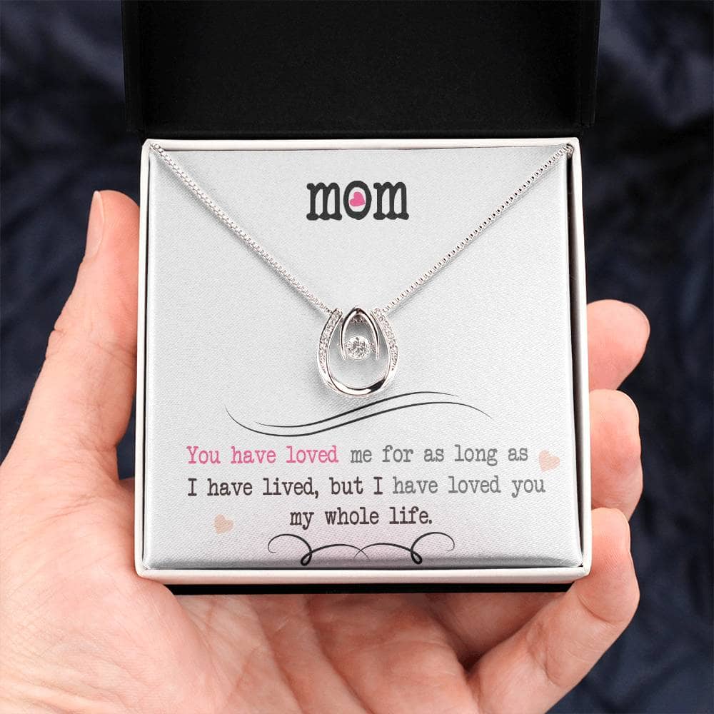 A hand holding a Personalized Mother Necklace in a box, symbolizing the infinite love and care of a mother-child relationship.