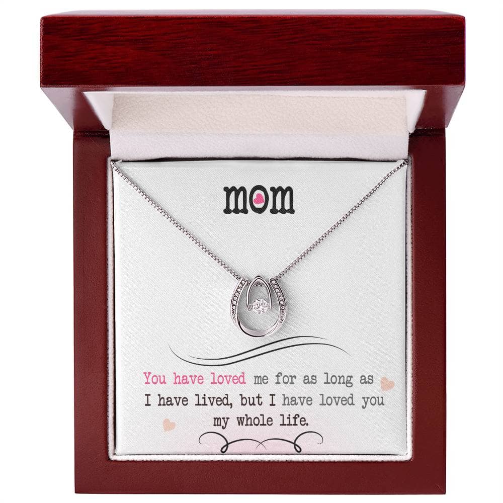 A close-up of a Personalized Mother Necklace in a box, featuring a hand-shaped pendant with a diamond-like cubic zirconia.