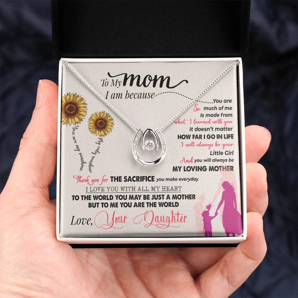 Alt text: "A hand holding a Personalized Mother Necklace in a box, symbolizing the enduring bond between mothers and their babies."