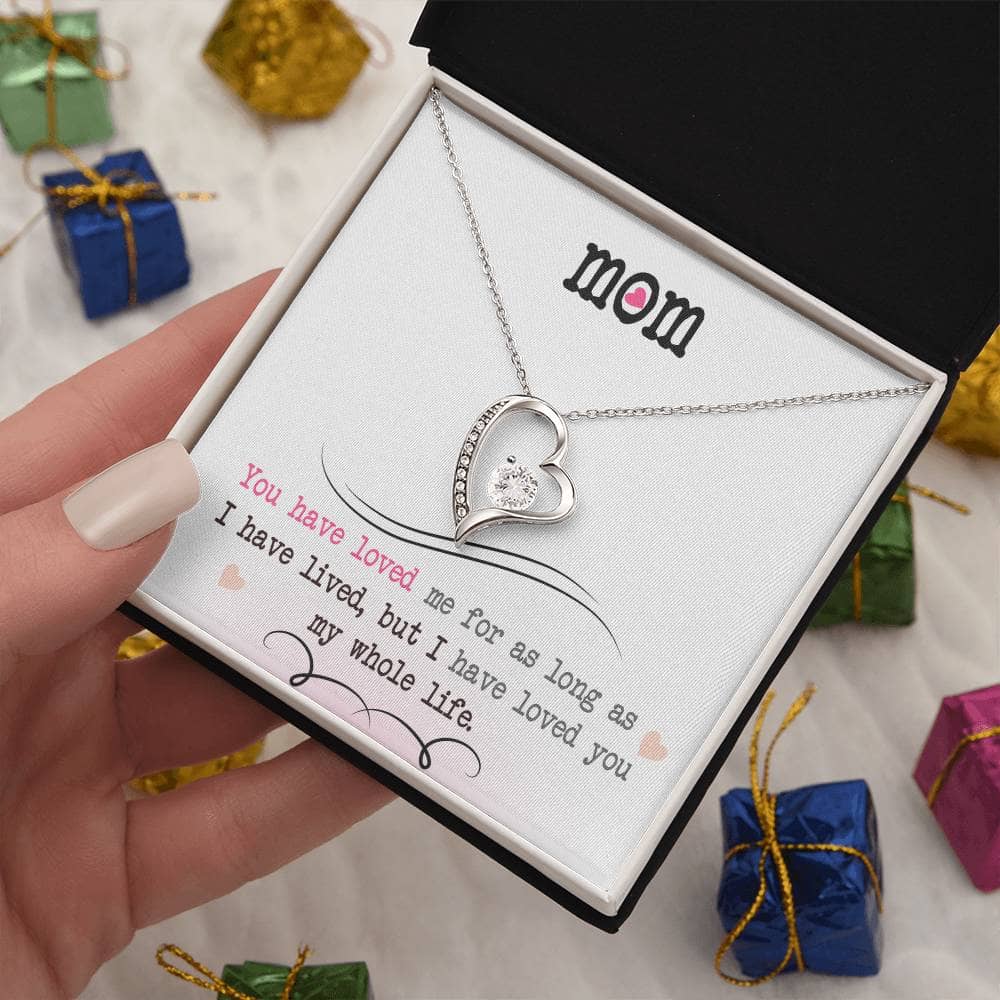 Alt text: "A hand holding a Personalized Mother Necklace gift box with a heart-shaped pendant and LED-lit mahogany-style luxury box."