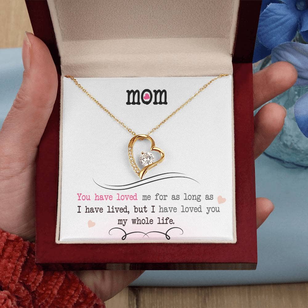 A hand holding a Personalized Mother Necklace gift, featuring a heart-shaped pendant with a cushion-cut cubic zirconia. The necklace is elegantly presented in a luxury box with LED lighting. A symbol of eternal love and a perfect gift for beloved mothers.