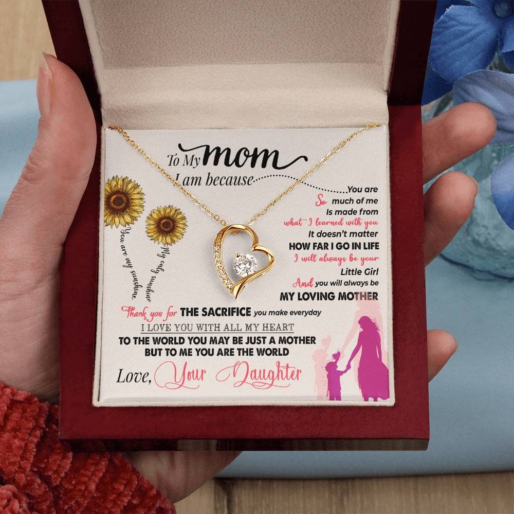 Alt text: "A hand holding a Personalized Mother Necklace in a box, featuring a heart-shaped pendant with a diamond. Ideal gift to honor mothers, symbolizing love and care. From Bespoke Necklace."