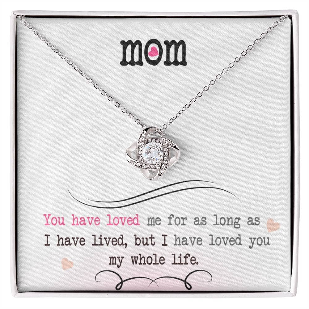 A close-up of a Personalized Mother Necklace - Love Knot Jewelry, featuring a heart-shaped pendant adorned with cubic zirconia crystals.