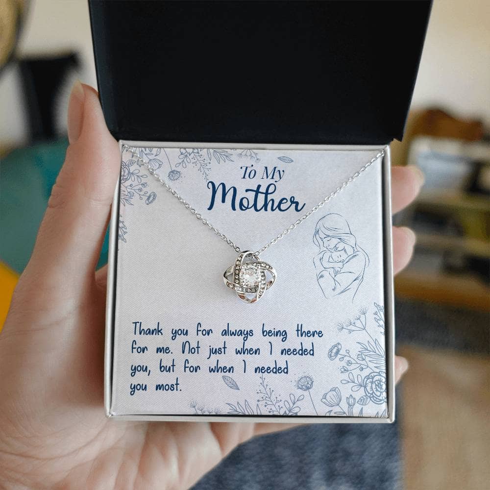 Alt text: "A hand holding a Personalized Mother Necklace in a box, symbolizing the unbreakable bond between a mother and her children."