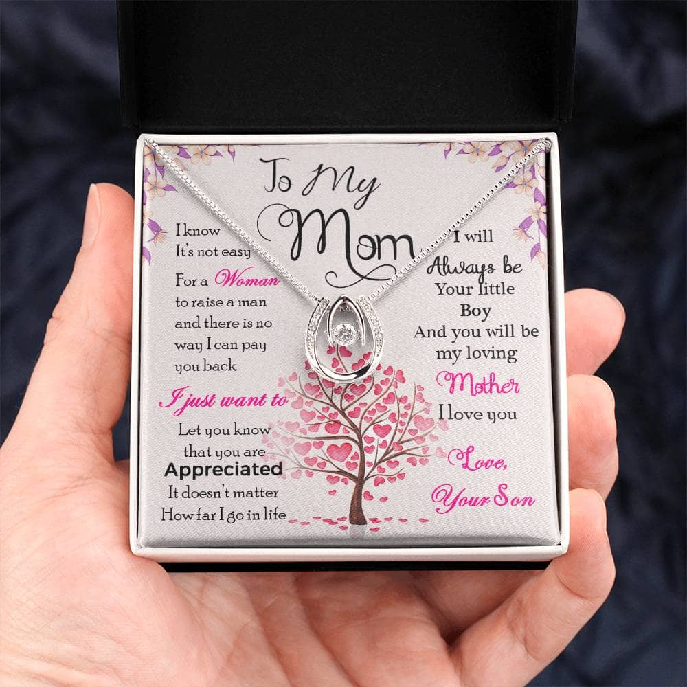 Alt text: "A hand holding a Personalized Mother Necklace in a luxurious box with LED lighting"