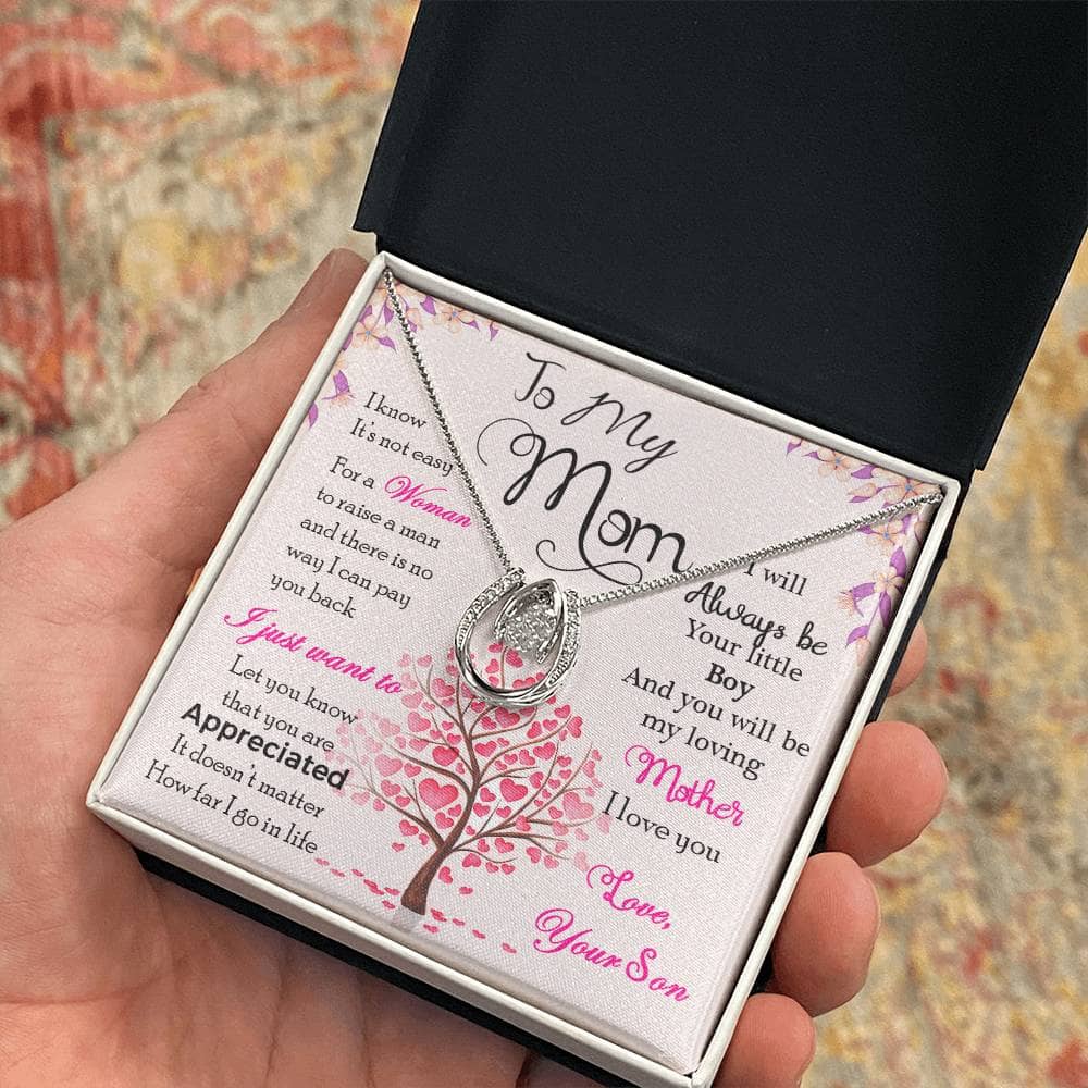 Alt text: "A hand holding a Personalized Mother Necklace in a box, adorned with cubic zirconia. Symbol of love and care, perfect for gifting."