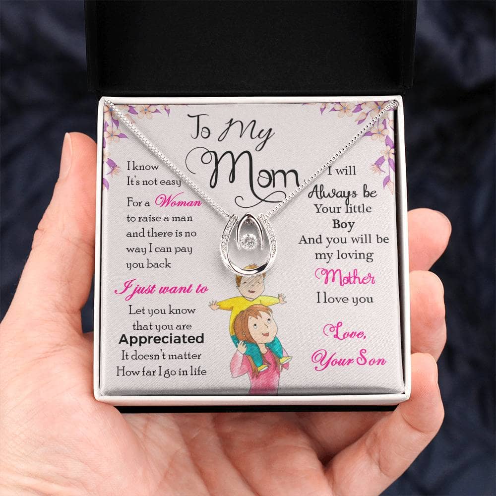 A hand holding a Personalized Mother Necklace in a box, symbolizing the cherished bond between a mother and child.