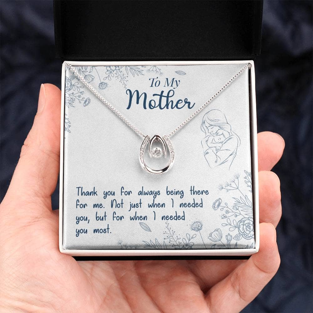 A hand holding a Personalized Mother Necklace - Thankful Son/Daughter Gift, featuring a heart-shaped pendant with a cushion-cut cubic zirconia.