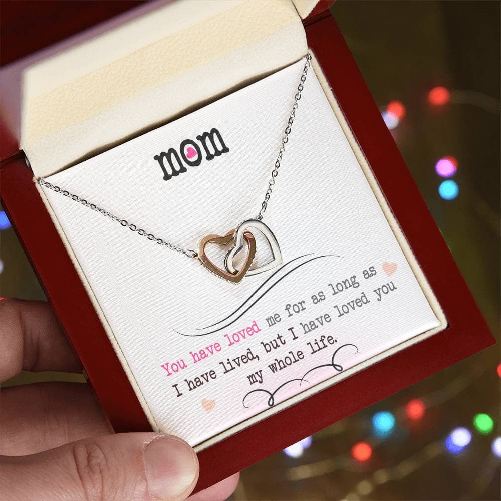 Alt text: "A hand holding a Personalized Mother Necklace with cushion-cut cubic zirconia accents in a box"