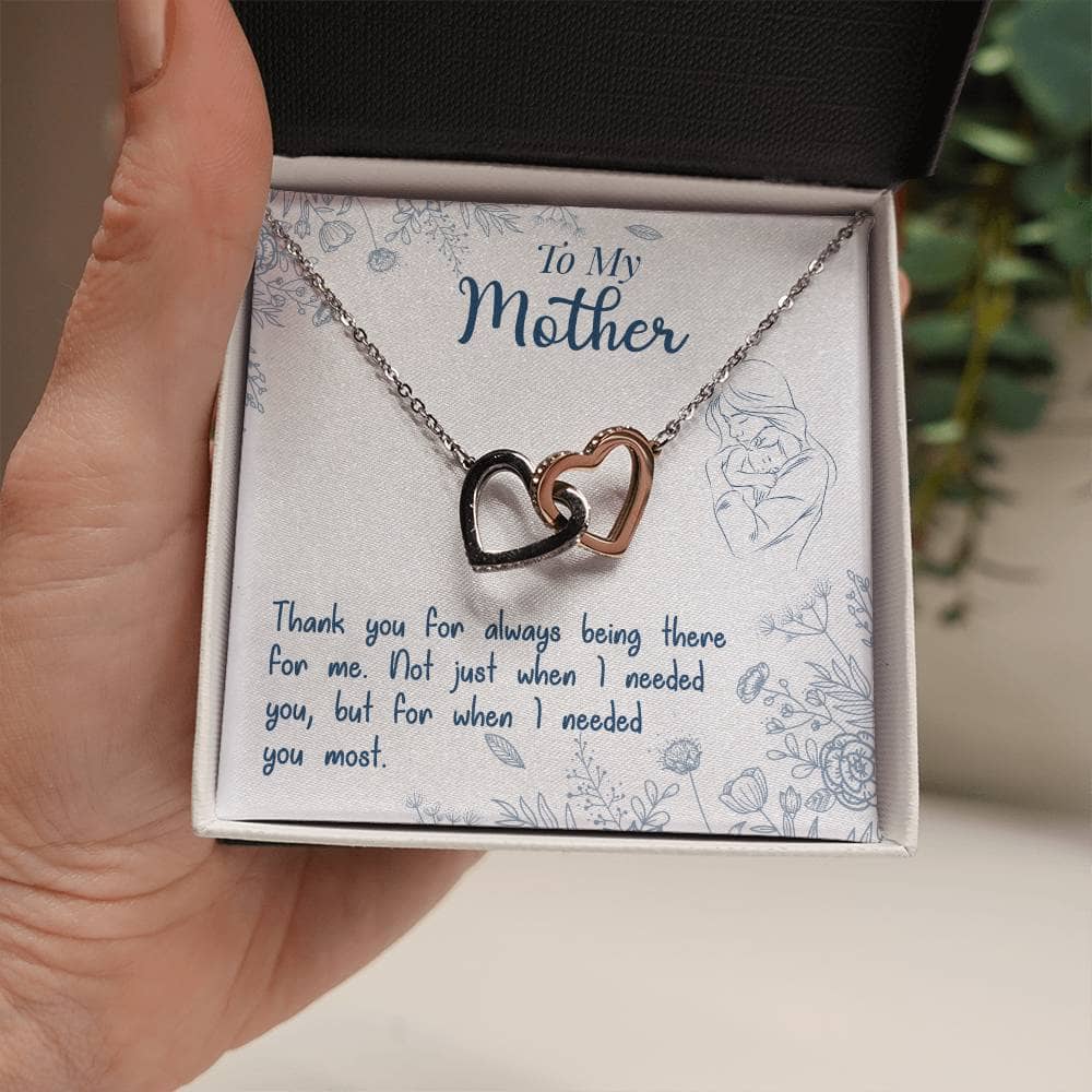 A hand holding a Personalized Mother Necklace with two heart-shaped pendants adorned with cubic zirconia crystals, symbolizing the unbreakable bond between mother and child.