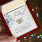 A hand holding a Personalized Soul Sister Necklace with Heart Pendant in a box.