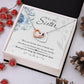 A necklace in a box with pine cones and berries, representing the Personalized Soul Sister Necklace With Heart Pendant.