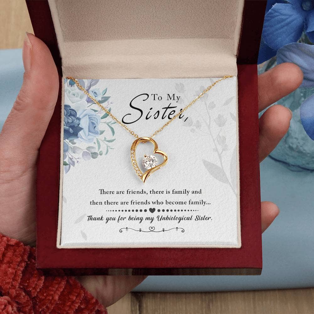 A hand holding a Personalized Soul Sister Necklace with an elegant heart pendant in a box.