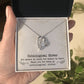 A hand holding a Personalized 'Unbiological Sisters' Forever Love Necklace pendant, featuring connected hearts or love knot designs, adorned with cubic zirconia.
