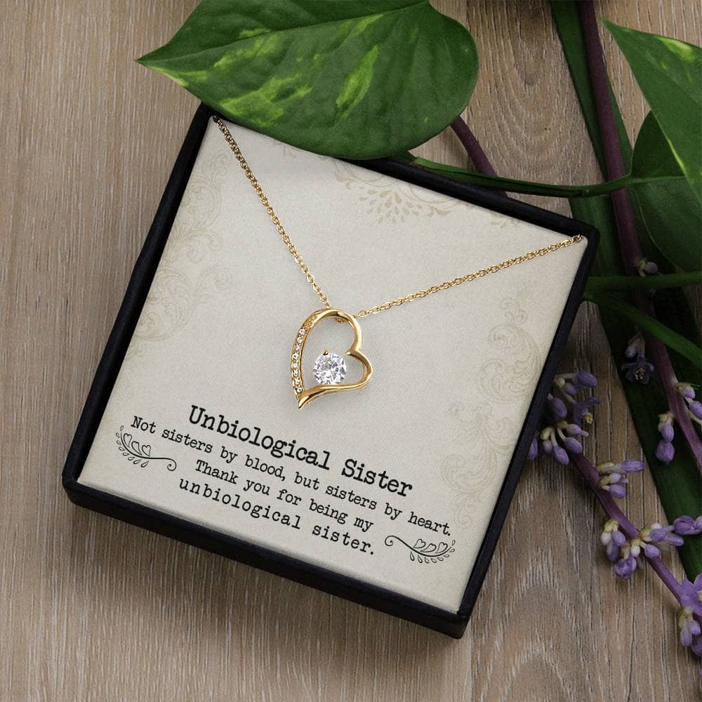 Alt text: "Personalized Unbiological Sisters Necklace with heart-shaped pendant in gold, adorned with cubic zirconia"