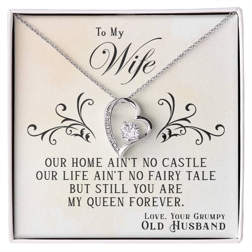 Alt text: "Personalized Wife Necklace: Heart-shaped pendant with cushion-cut cubic zirconia centerpiece, adorned with petite crystals. Comes in elegant mahogany-style box. Reflective white or lustrous yellow gold options. Adjustable chain for perfect fit."