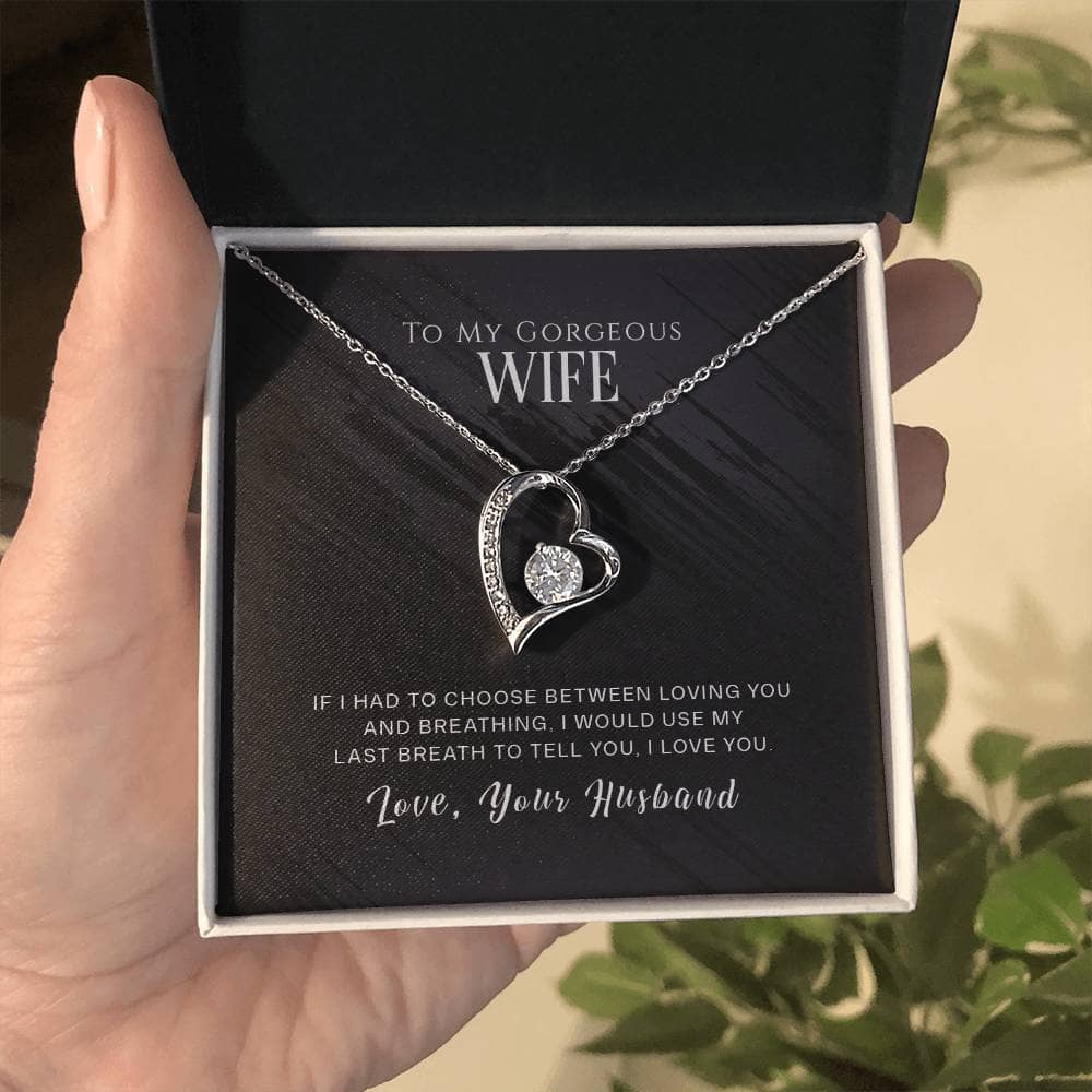 A hand holding a Personalized Wife Necklace - Eternity Love Pendant in a box.