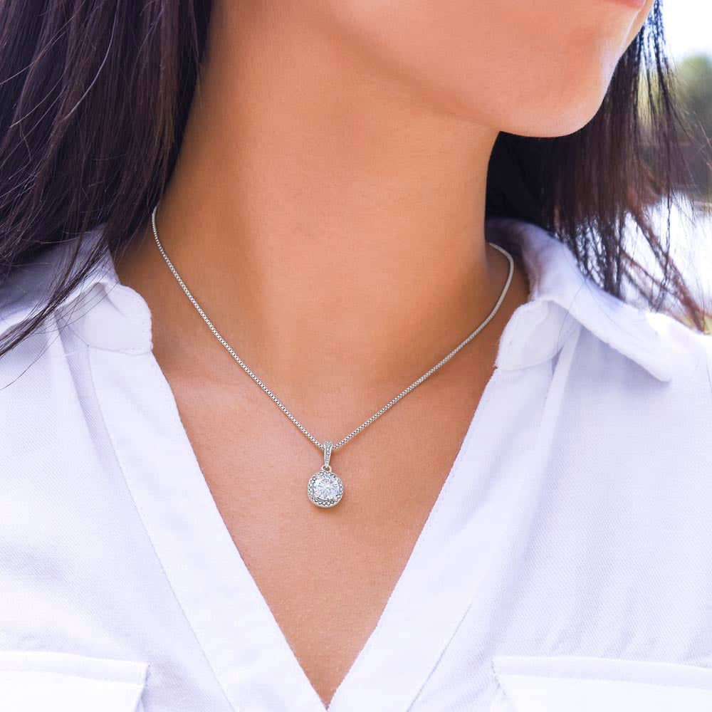 A woman wearing a personalized wife necklace, symbolizing everlasting love. A shimmering cushion-cut cubic zirconia pendant on a white gold chain.