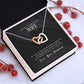 Heart-shaped necklace in box with romantic message to wife from husband.