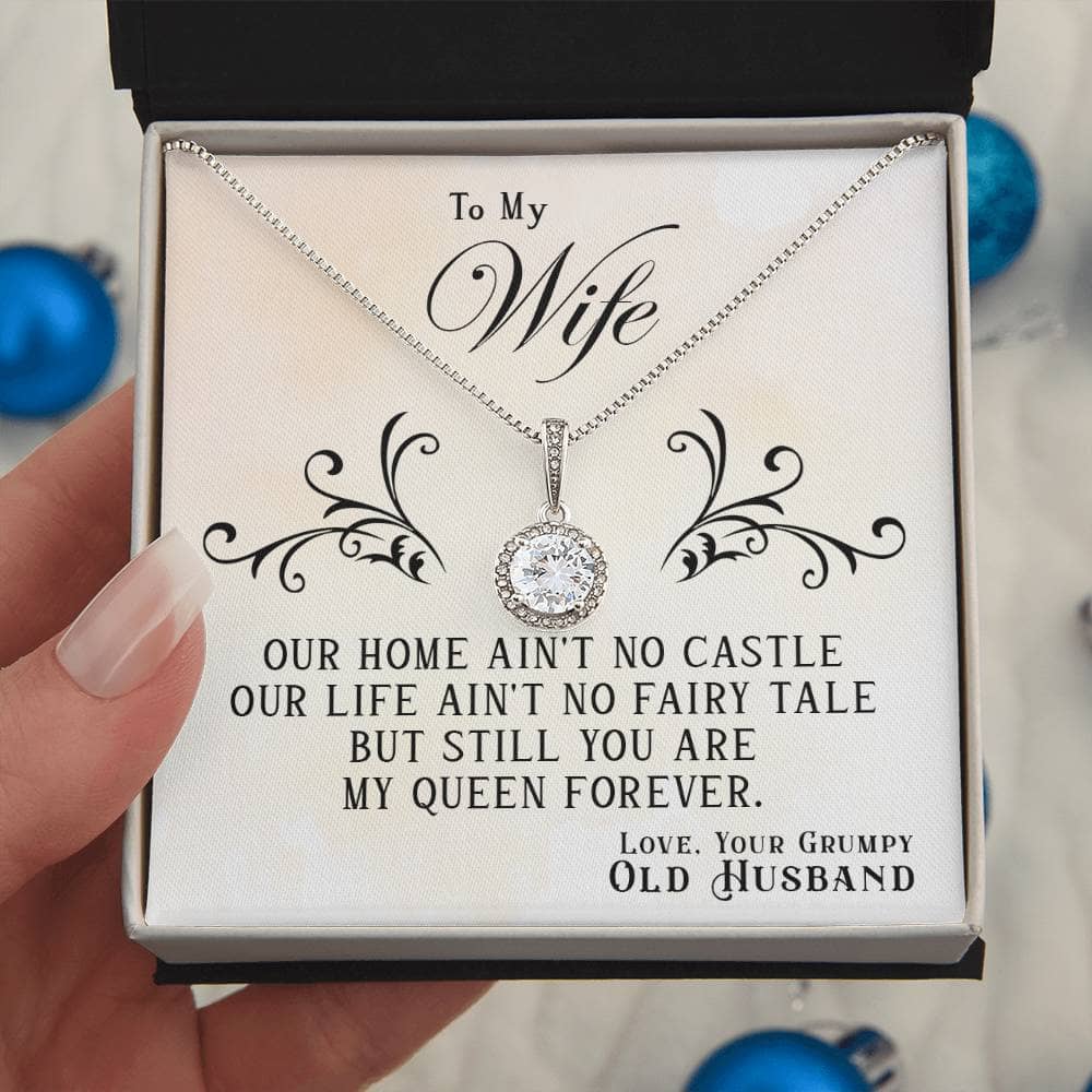 Alt text: "Hand holding personalized wife necklace with cubic zirconia in a box"
