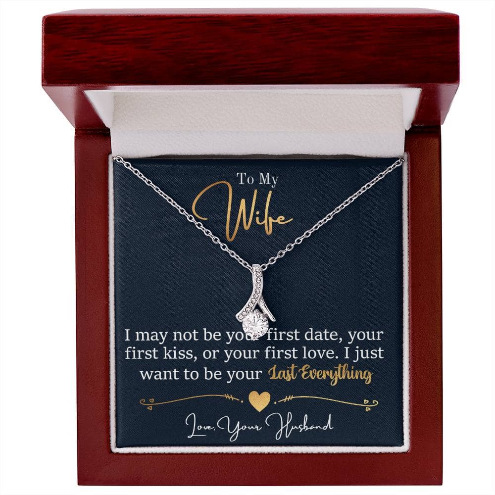 Alt text: "Personalized Wife Necklace: A ribbon-shaped pendant with a 7mm cubic zirconia on an adjustable chain, presented in a soft touch box."